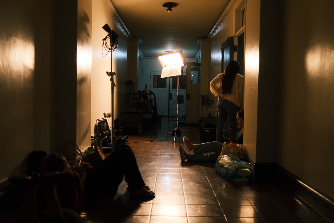 Crew in a dark hallway with lighting equipment