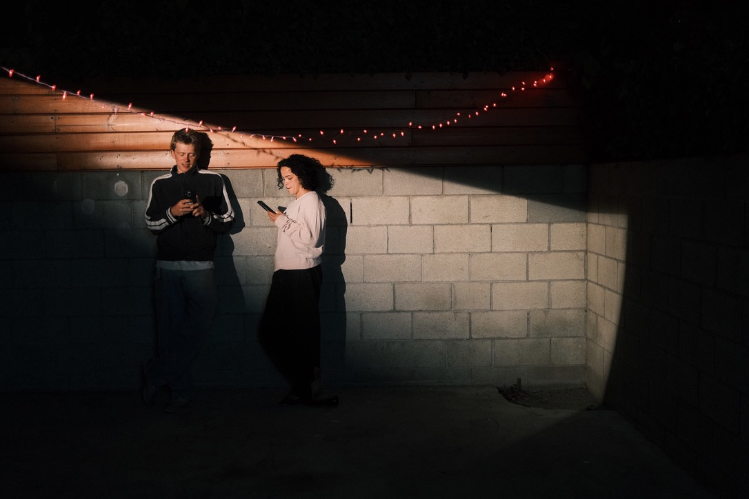 Crew checking phones under string lights