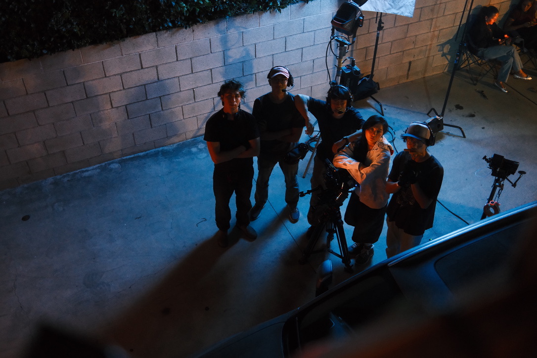 Crew gathered around a camera, overhead angle