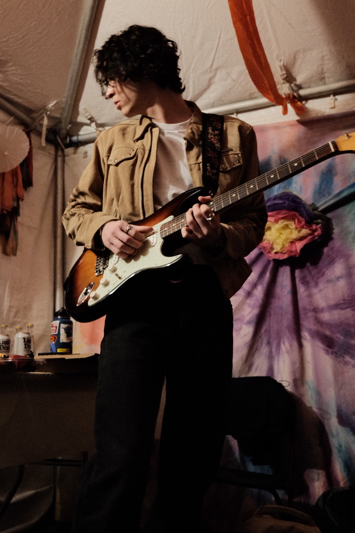 Guitarist performing under a tent