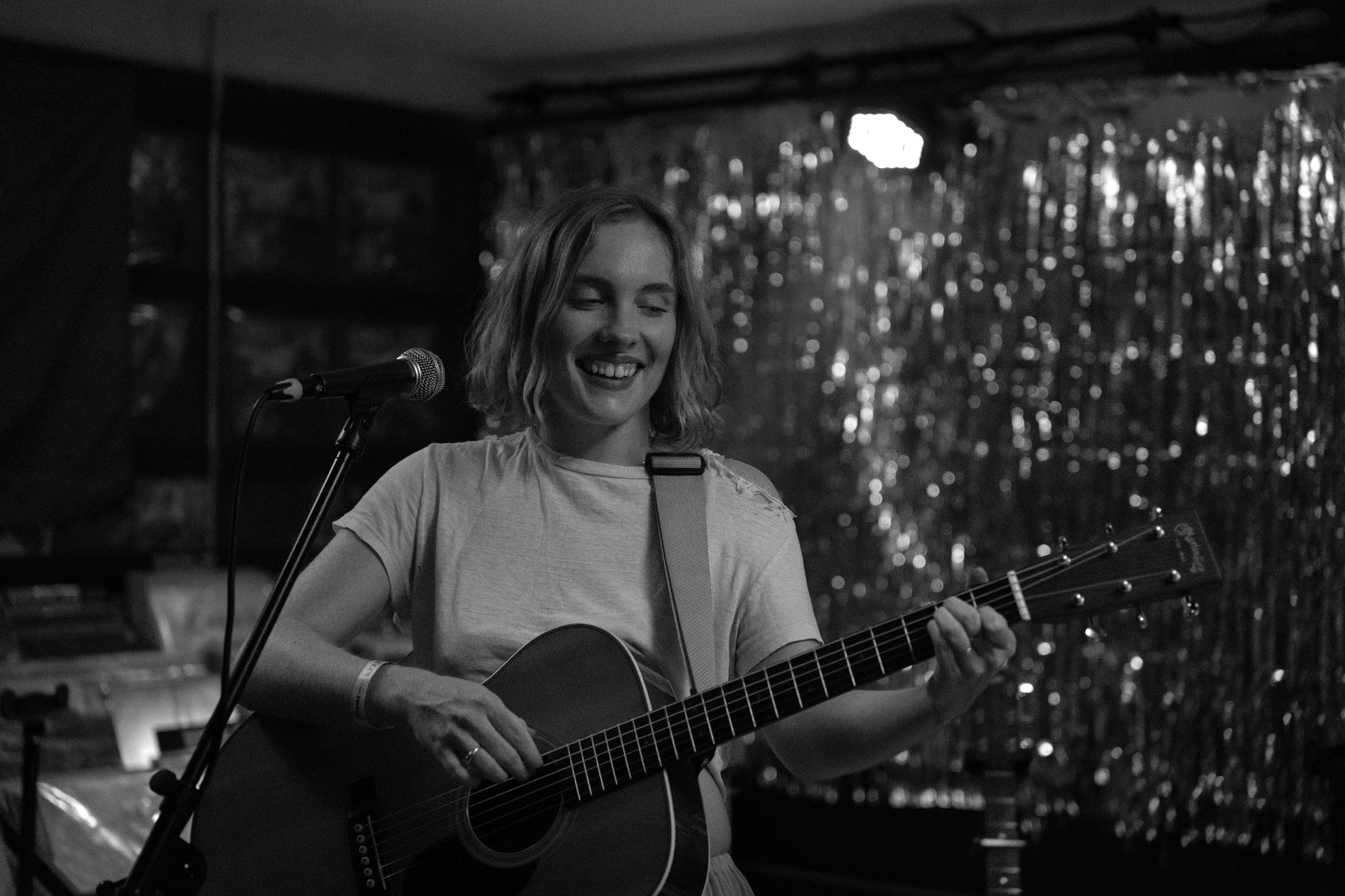 Musician playing acoustic guitar and singing, black and white
