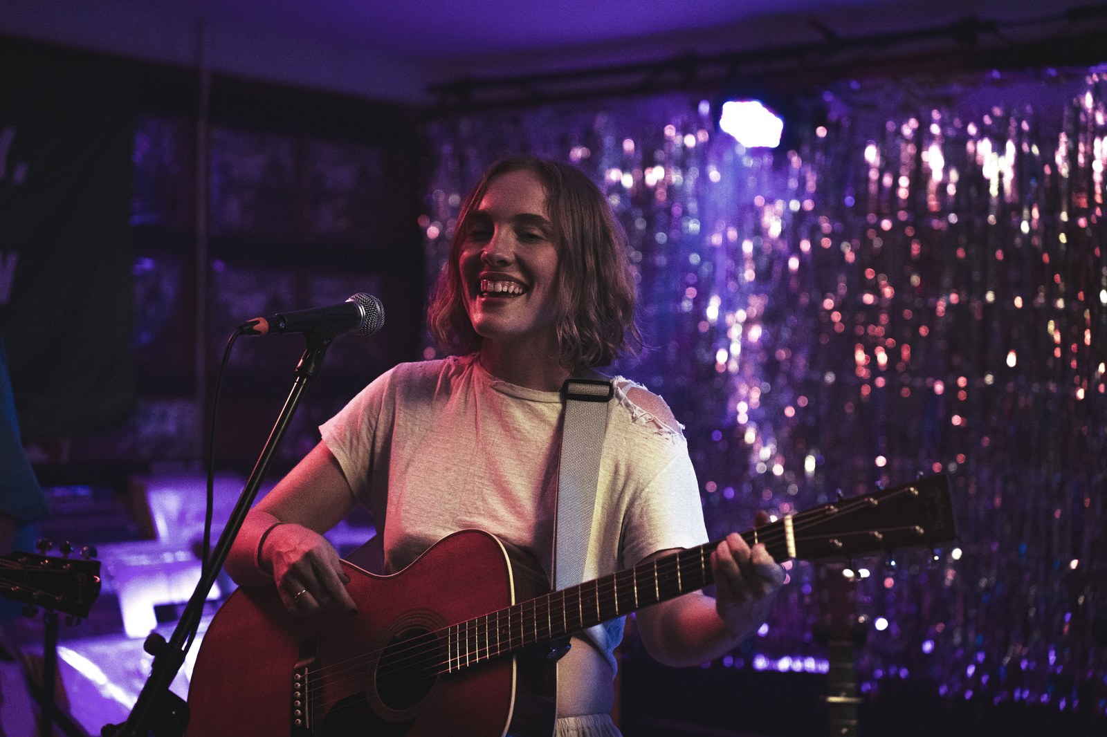 Musician singing under purple stage light