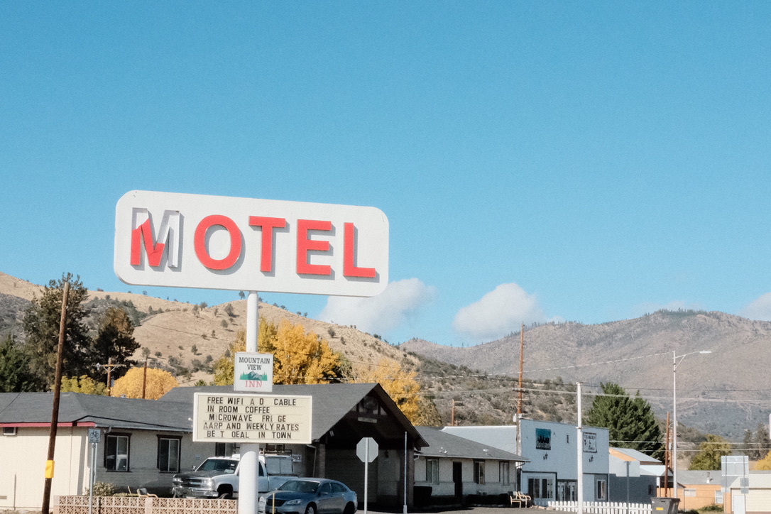 Roadside motel sign against mountains